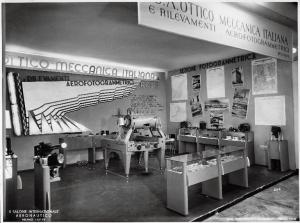 Fiera di Milano - Salone internazionale aeronautico 1937 - Settore accessori, strumenti e materie prime lavorate e semilavorate - Stand della S.A. ottico meccanica italiana e rilevamenti aerofotogrammetrici