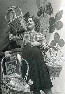 Fiera di Milano - Campionaria 1940 - Giovane donna con cestini di dolciumi