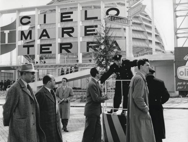 Fiera di Milano - Campionaria 1957 - Padiglione della Fiat - Installazione segnaletica con vigile - Visitatori
